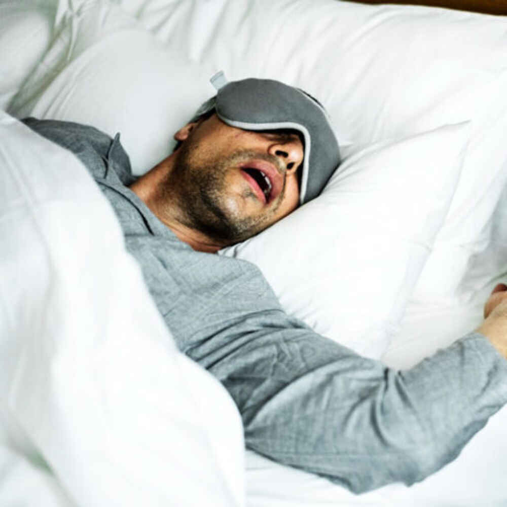 Person sleeping on bed with possible snoring and sleep apnea
