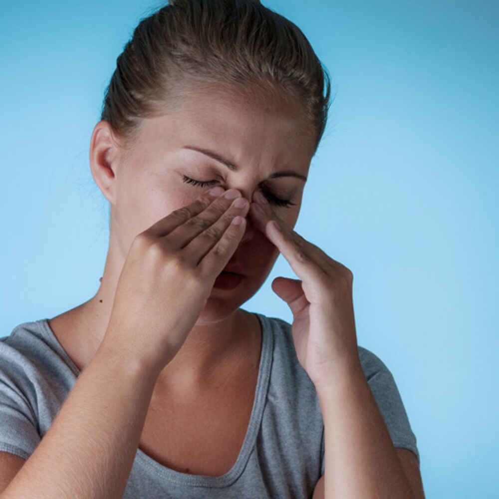 Women touching nose due to nasal or sinus issues
