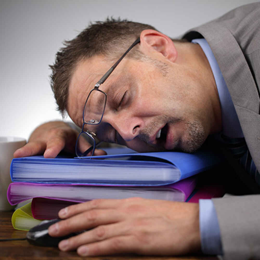 Man sleeping on folders and desk