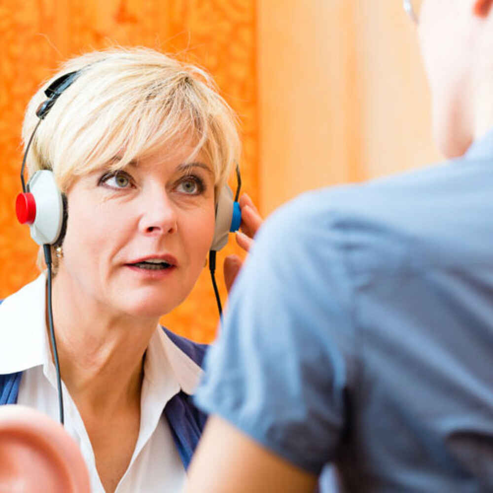 Doctor with patient wearing headphones for hearing test