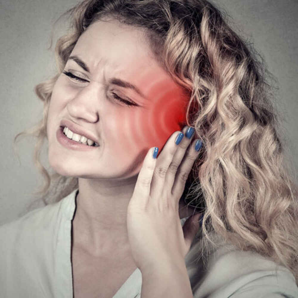 Woman struggling with tinnitus ringing in her ears