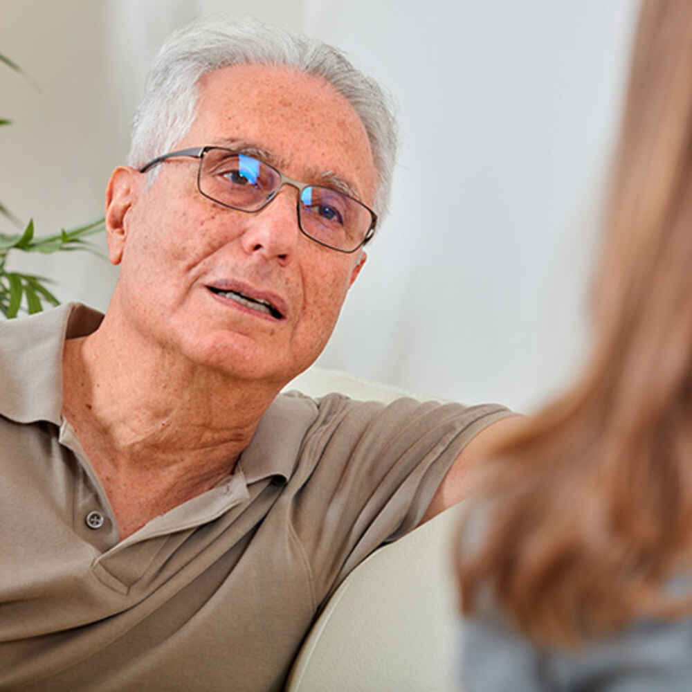 Older man talking to a woman potentially about voice issues
